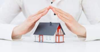 Assurance emprunteur en 2021 : elle peut représenter plus de 50 % du coût total du prêt immobilier Une maison en jouet protégée par des mains