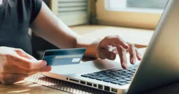 Un homme avec une carte de crédit devant son ordinateur