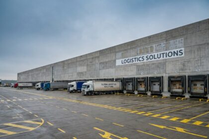 Entrepôt logistique moderne avec quais de chargement et camions, illustrant l'investissement en SCPI logistique